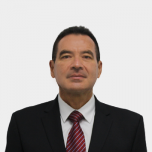 La foto fue tomada en primer plano, con fondo blanco y el profesor en el centro Mario Isidoro Bueno Duran
