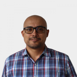 La foto fue tomada en primer plano, fondo blanco y el profesor Fabio Alberto Camargo Figuera está situado en el centro.