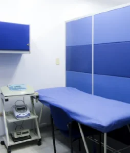 Salón con camilla y equipos fisioterapeutos.
