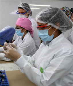 Foto donde aparecen tres estudiantes revisando muestras en el laboratorio