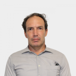 The photo was taken in the foreground, white background and the professor Juan Carlos Poveda Jaramillo is located in the center.