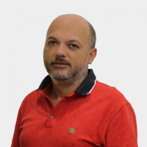 La foto fue tomada en primer plano, fondo blanco y el profesor Jorge Hernan Quintero está situado en el centro.