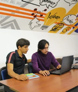 Close-up of two students working on a computer.