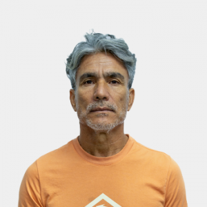 La foto fue tomada en primer plano, fondo blanco y el profesor Milton Arciniegas está situado en el centro.