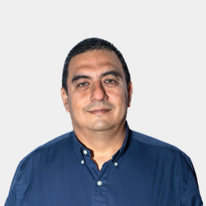 La foto fue tomada en primer plano, fondo blanco y el profesor Julio Andrés Pedraza está situado en el centro.
