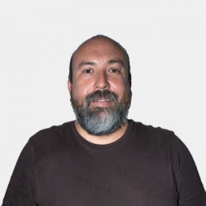 The photo was taken in close-up, with a white background, and the professor Julian Gustavo Rodríguez is positioned in the center.