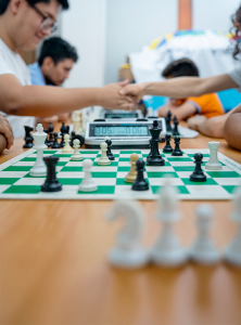 Estudiantes en clase de ajedrez estrechando manos