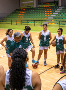 Selección de baloncesto femenino conversando con el entrenador.