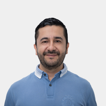 La foto fue tomada en primer plano, fondo blanco y el profesor Andres Giovanni Gonzalez está situado en el centro.