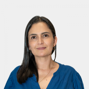 La foto fue tomada en primer plano, fondo blanco y la profesora Karime Vargas está situada en el centro.