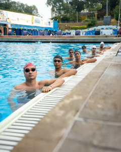 Male swim team students posing in the pool