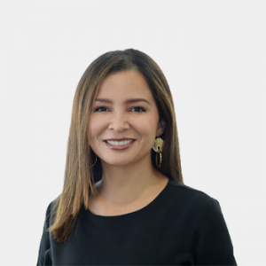 La foto fue tomada en primer plano, fondo blanco y la profesora Alexandra Cortes Aguilar está situada en el centro.