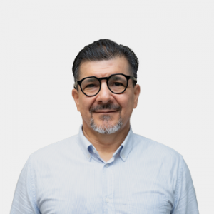 La foto fue tomada en primer plano, fondo blanco y el profesor Alonso Silva Rojas está situado en el centro.