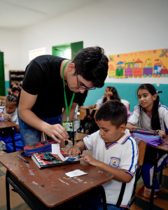 Undergraduate student helping a child with schoolwork in a classroom