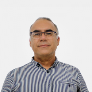 La foto fue tomada en primer plano, fondo blanco y el profesor Guillermo Mejia está situado en el centro.