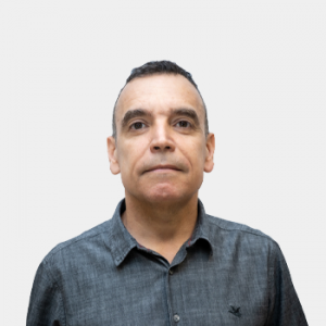 The photo was taken in close-up, with a white background, and the professor Jhon Jairo Caceres is positioned in the center.
