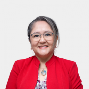 La foto fue tomada en primer plano, fondo blanco y la profesora Maika Karen Gambus Ordaz está situada en el centro.