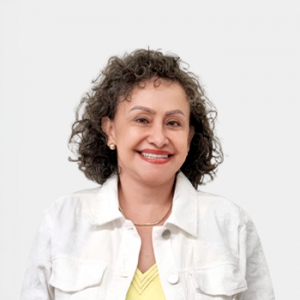 La foto fue tomada en primer plano, fondo blanco y la profesora Ruth Zárate Rueda está situada en el centro.