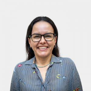 La foto fue tomada en primer plano, fondo blanco y la profesora Sandra Rocio Villamizar está situada en el centro.