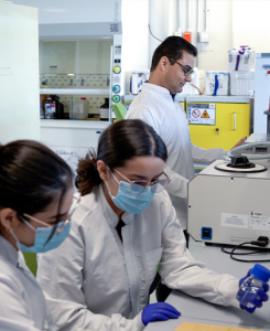 Estudiantes y profesor trabajando en laboratorio