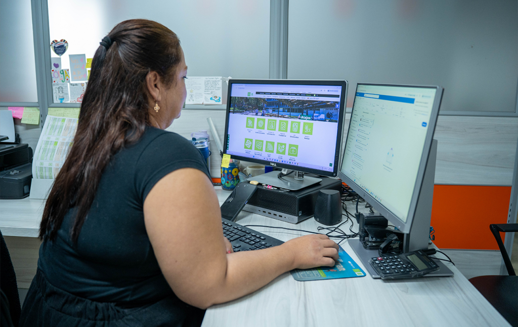 Funcionaria haciendo anotaciones en su computador